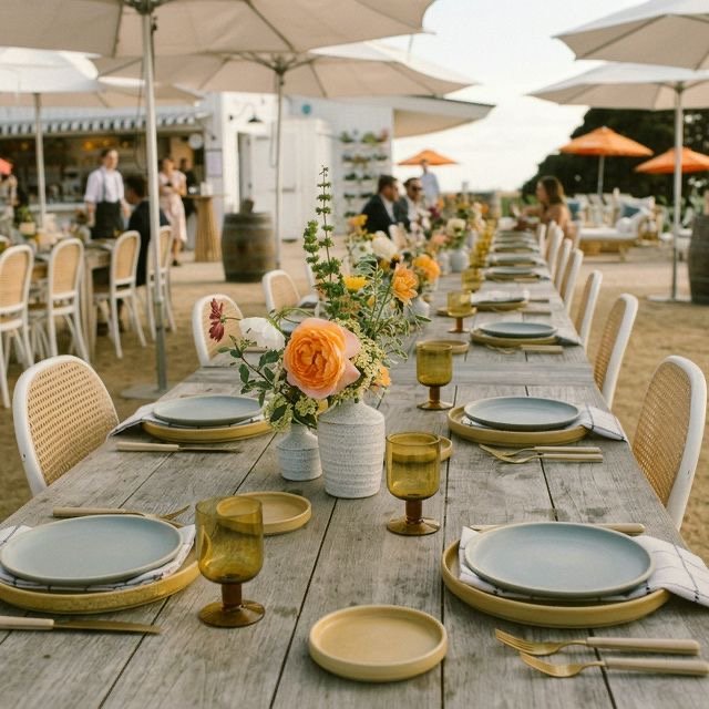 Long table dressed with flowers and wine glasses for a celebration on the patio