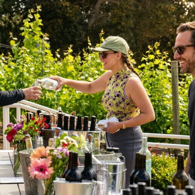 Wine being poured at a tasting beside the vineyard